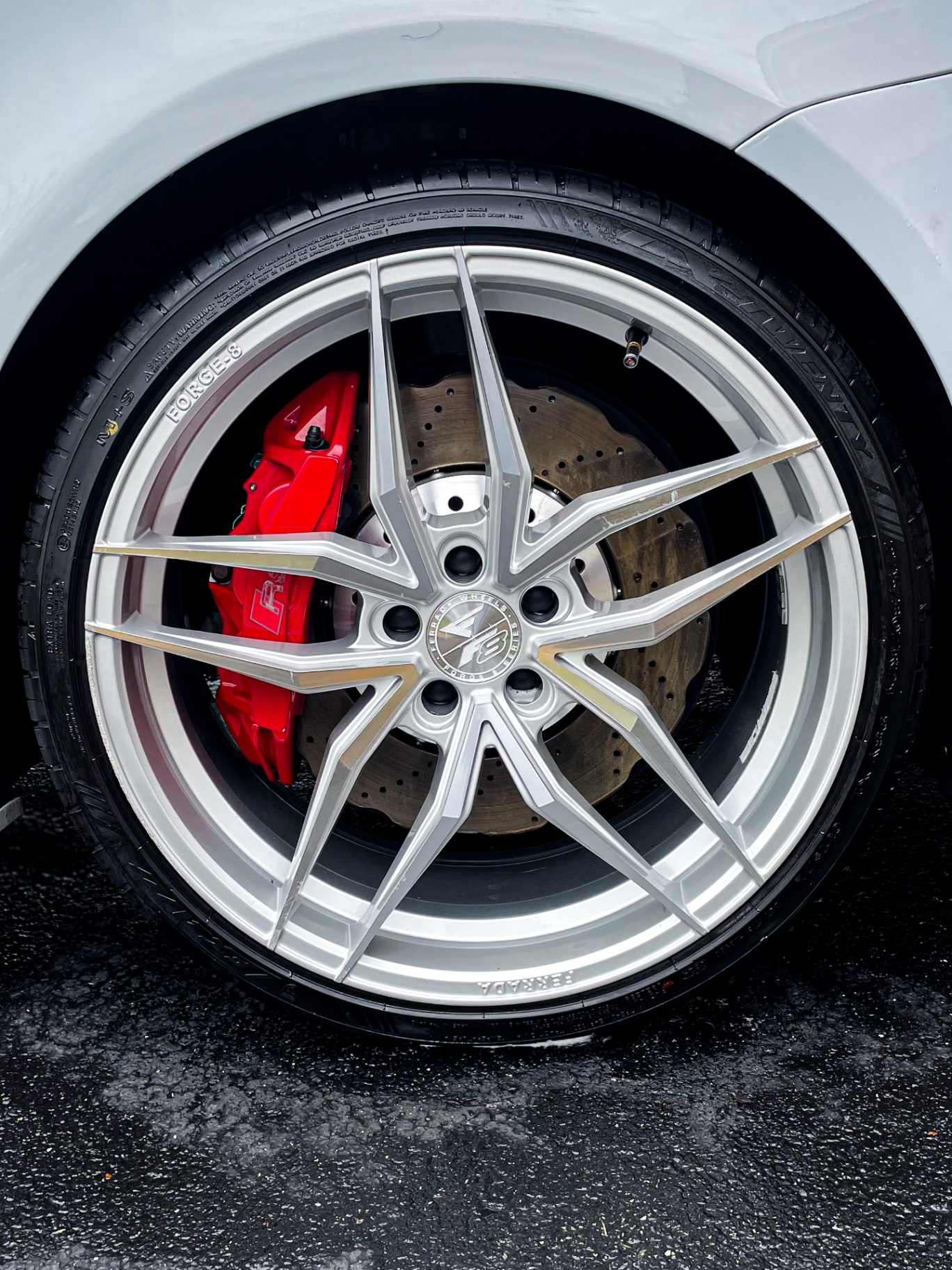 Black luxury car with water beads detailed by Velair Auto Care